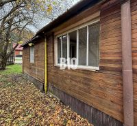 Ein Einfamilienhaus in Kotešová mit einer älteren Holzfassade, umgeben von Herbstblättern und Bäumen.