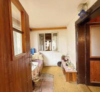 Innenraum eines Einfamilienhauses mit Holzverkleidung und einfacher Einrichtung.
