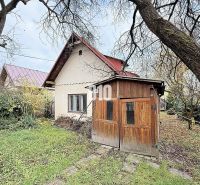 Ein Einfamilienhaus in Kotešová mit einem Holzunterstand und einem Garten im Herbst.