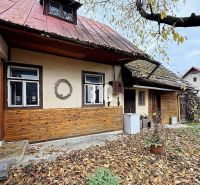 Ein Einfamilienhaus in Kotešová mit alter Holzverkleidung und fallendem Laub im Garten.