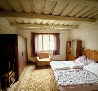 Schlafzimmer in einem Einfamilienhaus mit Holzdecke, Bett und Möbeln.