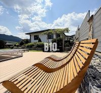 Holzliegestühle auf der Terrasse bei der Villa in Súľov-Hradná, mit Blick auf den Garten.