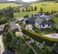 Eine Villa in Súľov-Hradná, umgeben von einem schönen Garten und hügeliger Landschaft.