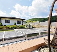 Eine Villa in Súľov-Hradná, ein gepflegter Garten mit Pool und eine bequeme Außensitzgelegenheit.