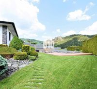 Der Garten der Villa in Súľov-Hradná mit gepflegtem Rasen und Blick auf die Berge.