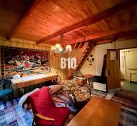 Das Innere der Hütte mit einer Holzdecke, einem dekorativen Teppich und bequemen Möbeln.