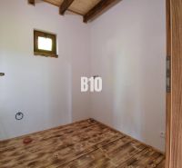 Holzboden und Türen im Innenraum der Hütte mit Oberlicht.