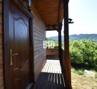 Eine Hütte bei Bytča mit einer Holzterrasse, umgeben von grüner Natur und Wäldern.