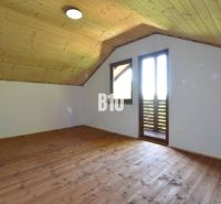 Dachzimmer mit Holzverkleidung und Holzboden in der Hütte bei Bytča.