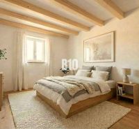 Das Innere der Hütte mit Holzbalken, einem bequemen Bett und einem Boden mit Holzdekor.