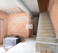 Innenraum der Immobilie eines im Bau befindlichen Einfamilienhauses mit Treppe und Ziegeln für den Bau.