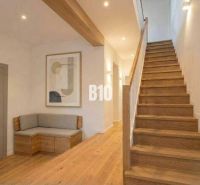 Innenraum einer Hütte mit Holzdekor, Treppe, Bank, Bild, neutrale Farben.