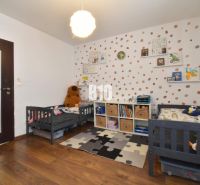 Kinderzimmer mit Kinderbetten, dekorativer Wand und Boden mit Holzdekor in einer 3-Zimmer-Wohnung.