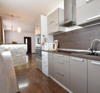 Küche in einer 3-Zimmer-Wohnung mit einer Küchenzeile und einem Boden in Holzoptik.