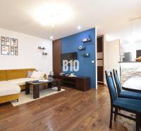 Wohnzimmer in einer 3-Zimmer-Wohnung mit Holzboden und stilvollen Möbeln.