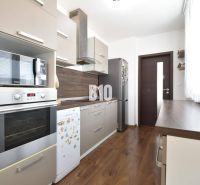 Küche in einer 3-Zimmer-Wohnung mit Holzboden und modernen Geräten.