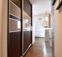 Der Flur in einer 3-Zimmer-Wohnung mit einem Holzboden und einem Einbauschrank.