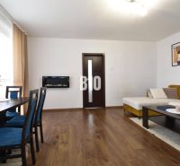Wohnzimmer in einer 3-Zimmer-Wohnung mit Holzboden, Sofa und Esstisch.