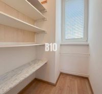 Kleiner Raum in einer Ferienwohnung mit Regalen und Fenster, Boden mit Holzdekor.