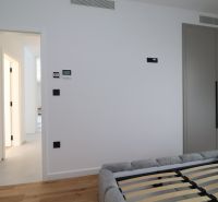 Schlafzimmer in der Villa mit Schrank, Bett und Boden in Holzoptik.