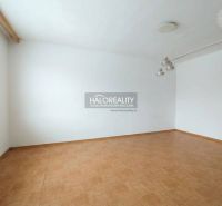 Ein Zimmer in einer Einzimmerwohnung mit weißen Wänden und einem Boden in Holzoptik.