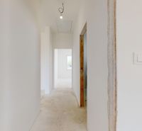 Der Flur in einem Einfamilienhaus mit weißen Wänden und Lichtschaltern.
