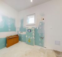 Innenraum eines Einfamilienhauses mit unvollendetem Badezimmer, freiliegenden Installationen und Gipskartonplatten.