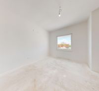 Ein leerer Raum in einem Einfamilienhaus mit weißen Wänden und einem Fenster.