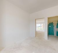 Unmöbliertes Interieur eines Einfamilienhauses mit weißen Wänden und Blick in den Garten.