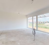 Helles Wohnzimmer in einem Einfamilienhaus mit großen Fenstern und Blick in den Garten.