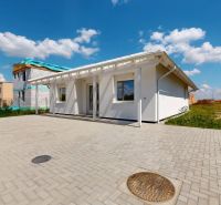 Ein Einfamilienhaus in Nový Svet mit Parkfläche und benachbarten Gebäuden.