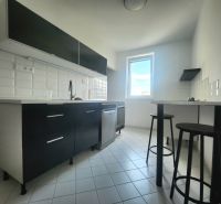 Küche in einer 3-Zimmer-Wohnung mit weißen Fliesen und dunklen Schränken.