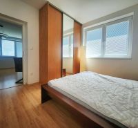 Schlafzimmer mit großem Schrank und Bett, Boden mit Holzdekor in einer 3-Zimmer-Wohnung.