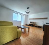 Wohnzimmer mit Sofa, Tisch und Holzboden in einer 3-Zimmer-Wohnung.