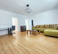 Wohnzimmer mit Sofa, Tisch und Boden in Holzoptik in einer 3-Zimmer-Wohnung.