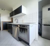 Küche mit weißen Fliesen, Spülmaschine aus Edelstahl und Kühlschrank in einer 3-Zimmer-Wohnung.