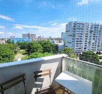 Blick vom Balkon auf Grünflächen, hohe Gebäude und klaren Himmel in Bratislava - Ružinov.