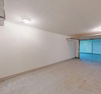 Geräumige Garagen mit weißen Wänden und Garagentor in Bratislava - Petržalka.