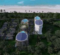 Wohnungsbau am Strand in Phuket mit modernen Gebäuden und Pools, umgeben von Palmen.