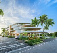 Wohnungsbau in Phuket mit moderner Architektur, umgeben von Palmen und Parkplätzen.