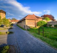 Ein gepflasterter Gehweg entlang eines historischen Gebäudes auf einem Gewerbegrundstück in Fiľakovo.