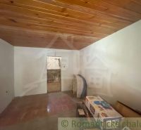 Innenraum eines Einfamilienhauses mit Holzdecke und Fliesenboden.