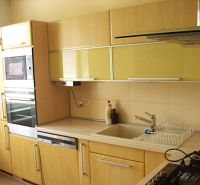 Küche in einer 2-Zimmer-Wohnung mit eingebauten Geräten und einem Boden in Holzoptik.