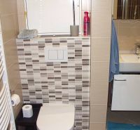 Badezimmer in einer 2-Zimmer-Wohnung mit Badewanne, Waschbecken und Fliesen in neutralen Farbtönen.