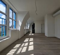 Ein geräumiges Zimmer mit großen Fenstern, Holzboden-Dekor in einer Einzimmerwohnung.
