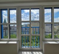 Blick aus einer Einzimmerwohnung auf die Skyline von Bratislava durch große Fenster.