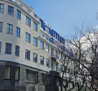 Ein Gebäude in Bratislava - Altstadt in der Poštová-Straße mit Bäumen im Vordergrund.