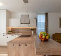 Küche mit Insel und Obst in einer 2-Zimmer-Wohnung, Boden mit Holzdekor.