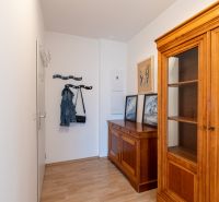 Innenraum einer 2-Zimmer-Wohnung mit Holzmöbeln und einem Boden in Holzoptik.