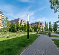Gebäude umgeben von Grünflächen und Gehwegen in der Bajkalská in Bratislava, geeignet für eine 2-Zimmer-Wohnung.